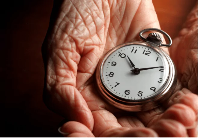 Close-up of an old person's hand gently holding a pocket watch, symbolizing the concept of owning time in Spanish expressions like “Tengo 20 años.”